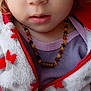 child, face, blue_eyes, necklace, jacket, red, white, purple_shirt, closeup, portrait, young, person, cute, expression, hands, skin, clothing, indoor, casual, fashion