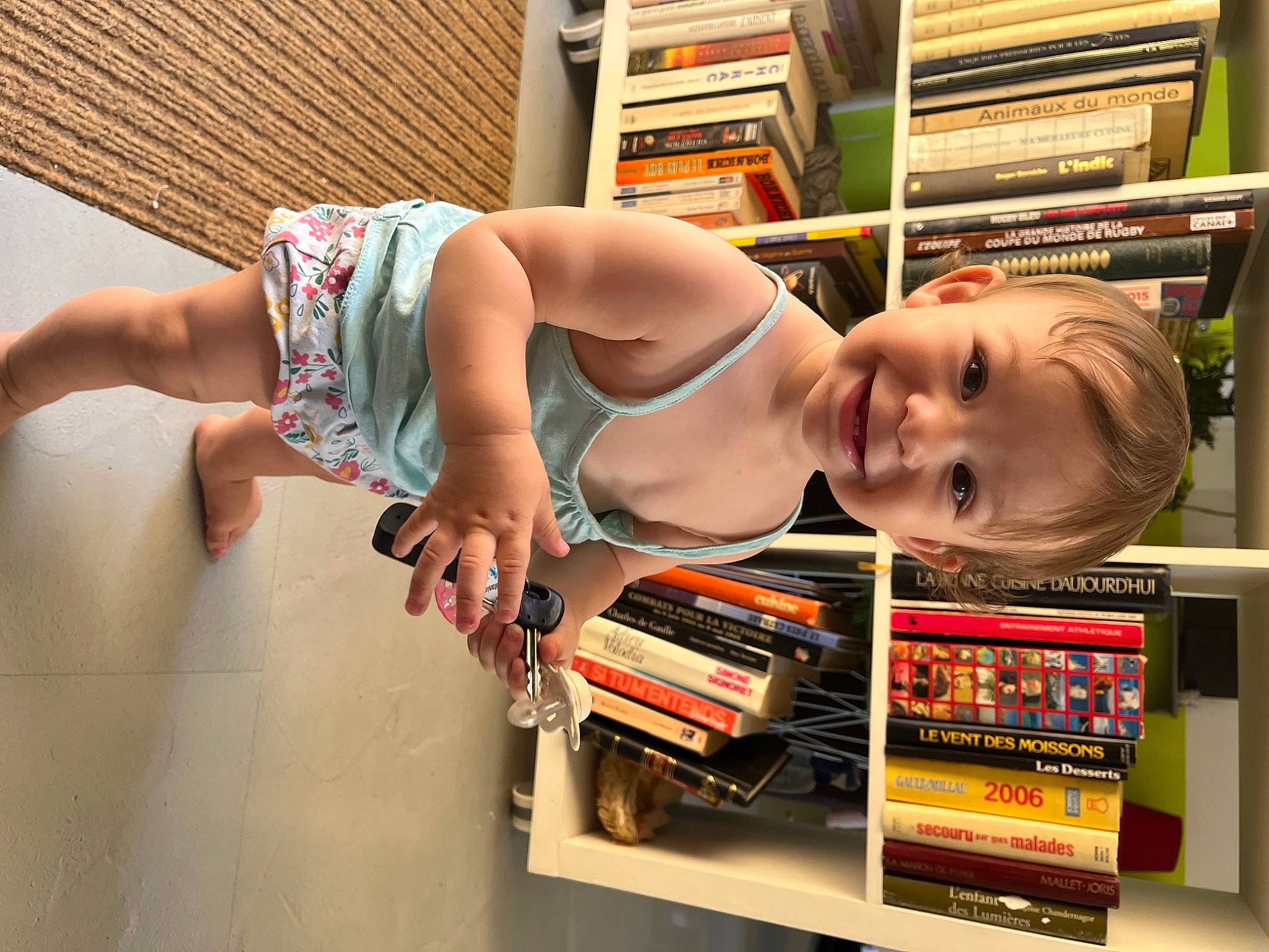 Kenza participe au concours pour gagner de l'argent avec cette photo : baby, book, bookcase, chest, child, elbow, flooring, fun, human_body, human_leg, person, publication, retail, room, shelf, shelving, smile, thigh, toddler, trunk