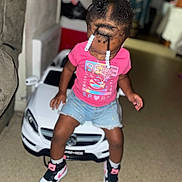 Kennedi joined the competition — help win amazing prizes! child, toddler, toy_car, indoor, braided_hair, beads, pink_shirt, denim_shorts, sneakers, floor, car, playing, cute, young_child, person, casual_clothing, fun, small_vehicle, looking_down, home