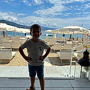 Emanuel a rejoint le concours — aidez-le/la à gagner de superbes lots ! beach, boy, child, cloud, daylight, lounge_chair, outdoor, person, relaxation, sand, sandal, sea, shore, shorts, sky, standing, summer, tshirt, umbrella, vacation