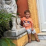 Théo a rejoint le concours — aidez-le/la à gagner de superbes lots ! casual, child, cute, door, hand, leaf, lion, marble, orange_tshirt, outdoor, plant, portrait, sandals, shorts, sitting, statue, step, summer, toddler, wall