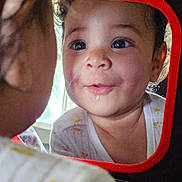 Dahlia joined the competition — help win amazing prizes! toddler, child, mirror, reflection, drool, face, curious, red_frame, indoors, window_light, close_up, cute, expression, clothing, infant, young_child, portrait, baby, looking, playful