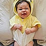 Dahlia is registered to the contest to win money with this photo: baby, child, infant, costume, yellow, duck, cute, face, expression, funny, pillow, blanket, couch, indoors, smile, hands, legs, soft, clothing, portrait
