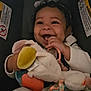 Dahlia joined the competition — help win amazing prizes! baby, child, smiling, plush_toy, curly_hair, bow, car_seat, white_sweater, happy, infant, cute, toy, hand, face, soft_toy, indoor, seatbelt, person, joy, playful