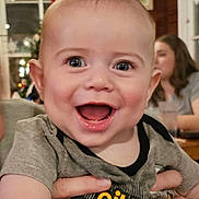 Oliver is registered to the contest to win money with this photo: baby, blurred_background, child, clothing, cute, expression, face, hands, happy, holding, human, indoor, infant, joy, mouth_open, people, person, portrait, shirt, smiling