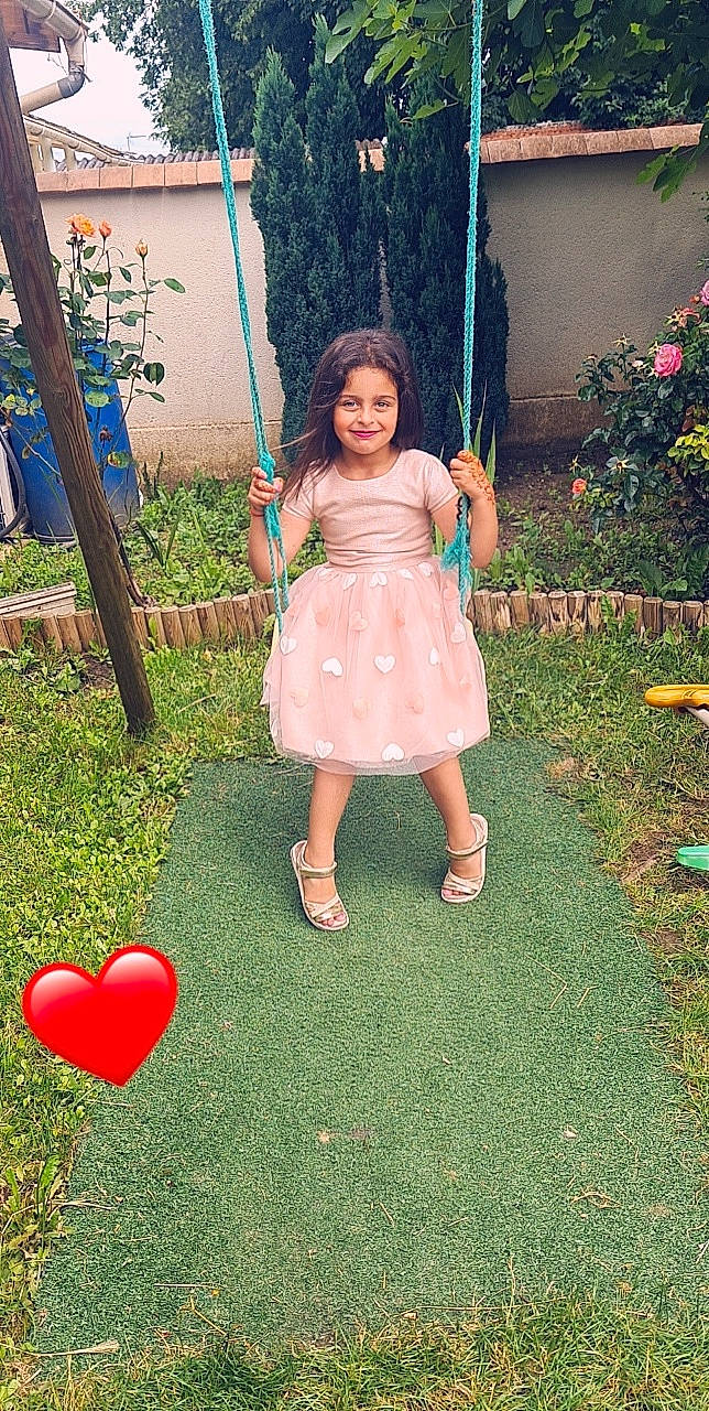 Alia a rejoint le concours — aidez-le/la à gagner de superbes lots ! balloon, botany, child, dress, eye, fun, grass, happy, head, human_body, joy, lawn, leg, leisure, people_in_nature, person, pink, plant, red, smile