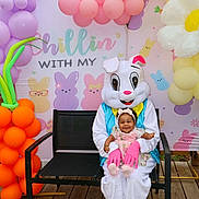 Josiegh is registered to the contest to win money with this photo: baby, child, easter_bunny, costume, balloons, bench, outdoor, decoration, carrot_balloon, flower_balloon, pastel_colors, smiling, festive, holiday, spring, headband, wooden_deck, person, happy, celebration