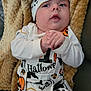 baby, baby_garment, black, blanket, clothing, costume, cute, face, halloween, hands, headwear, indoors, infant, orange, person, portrait, pumpkin, skull, soft_texture, white_clothing