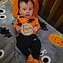 Oliver is registered to the contest to win money with this photo: baby, black, blanket, child, crib, cute, decor, expression, face, halloween, holiday, indoor, infant, orange, pajamas, pumpkin, resting, sock, striped_socks, wooden_sign