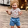 toddler, child, curly_hair, smiling, outdoor, pavement, floral_shirt, blue_shorts, walking, happy, person, daylight, sunlight, cute, young_child, casual_clothing, shoes, summer, playful, nature