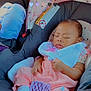 baby, bib, canopy, car_interior, car_seat, child, child_seat, floral_pattern, footwear, hand, indoors, infant, pacifier, peaceful, pink_clothing, portrait, seatbelt, sleeping, transportation, white_socks
