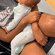 Isla joined the competition — help win amazing prizes! baby, sleeping, adult, arms, nike, shirt, gray_clothing, indoor, chair, skin, comfort, peaceful, person, holding, legs, hand, head, relaxation, toddler, closeup
