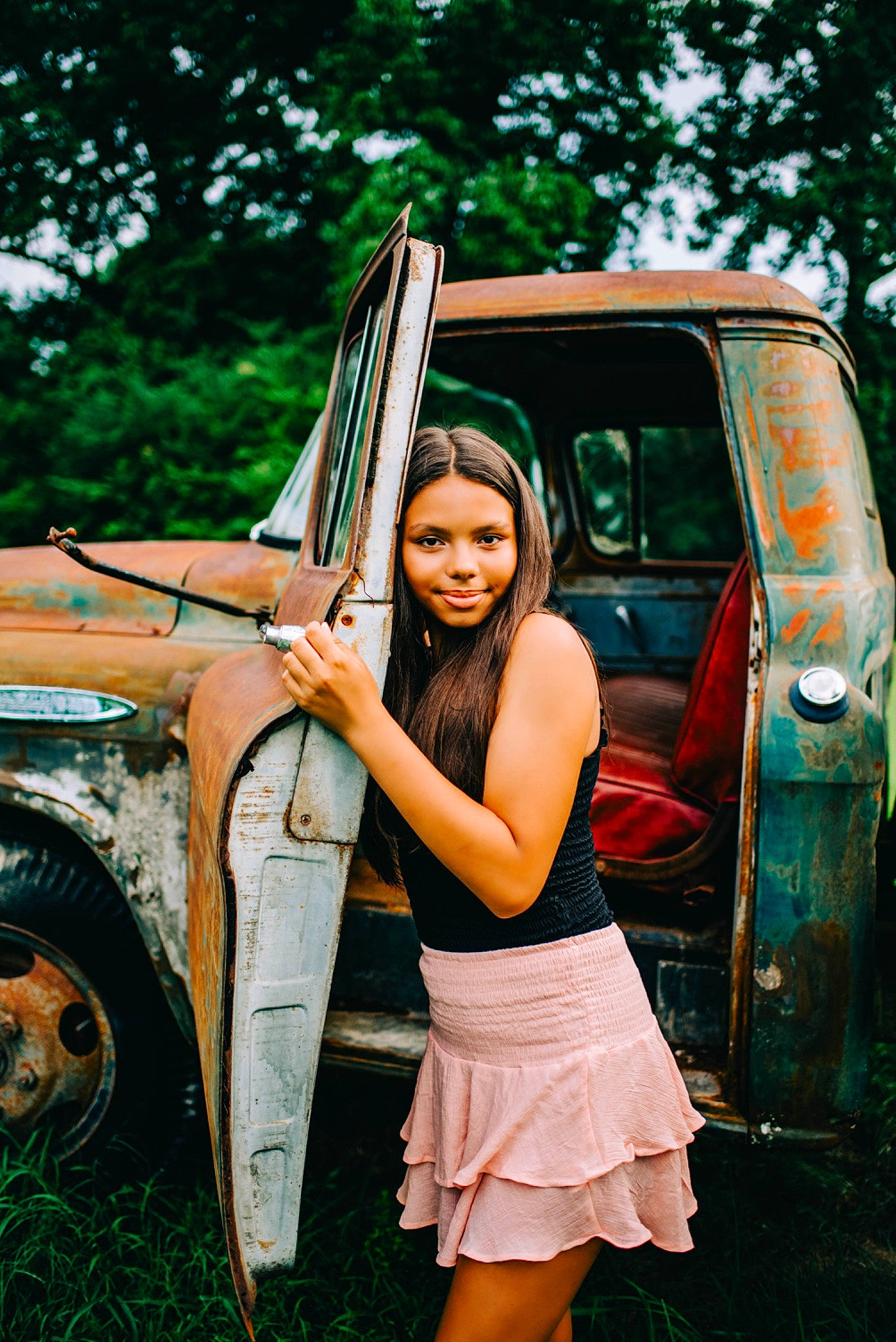 Erin is registered to the contest to win money with this photo: automotive_design, automotive_exterior, automotive_lighting, automotive_tire, bumper, car, dress, flash_photography, grass, happy, hood, joy, leg, motor_vehicle, person, plant, smile, tire, tree, vehicle