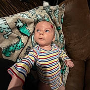 Westen joined the competition — help win amazing prizes! baby, blanket, casual, child, comfort, couch, cozy, curious, dinosaur_pattern, expression, face, head, home, indoor, infant, person, plush, reaching_hand, skin, striped_clothing