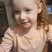 Josie-Bee joined the competition — help win amazing prizes! child, girl, red_hair, curly_hair, hair_clip, long_sleeve, shirt, indoor, smile, face, person, young, cute, portrait, standing, wood_floor, furniture, childhood, happy, casual