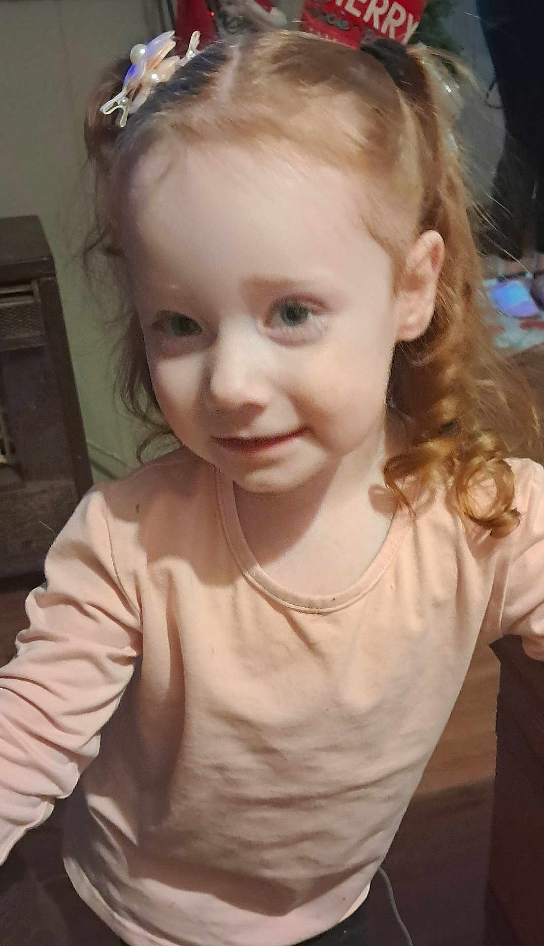 Josie-Bee joined the competition — help win amazing prizes! child, girl, red_hair, curly_hair, hair_clip, long_sleeve, shirt, indoor, smile, face, person, young, cute, portrait, standing, wood_floor, furniture, childhood, happy, casual