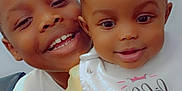 Sevyn is registered to the contest to win money with this photo: baby, bib, black_hair, child, closeup, cute, face, family, happy, holding, indoor, joy, person, pigtails, portrait, siblings, smiling, toddler, yellow_clothing, young