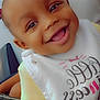 Sevyn is registered to the contest to win money with this photo: adult, baby, bib, child, closeup, clothing, cute, expression, fabric, face, hand, happy, indoor, joy, pattern, people, person, portrait, skin, smiling