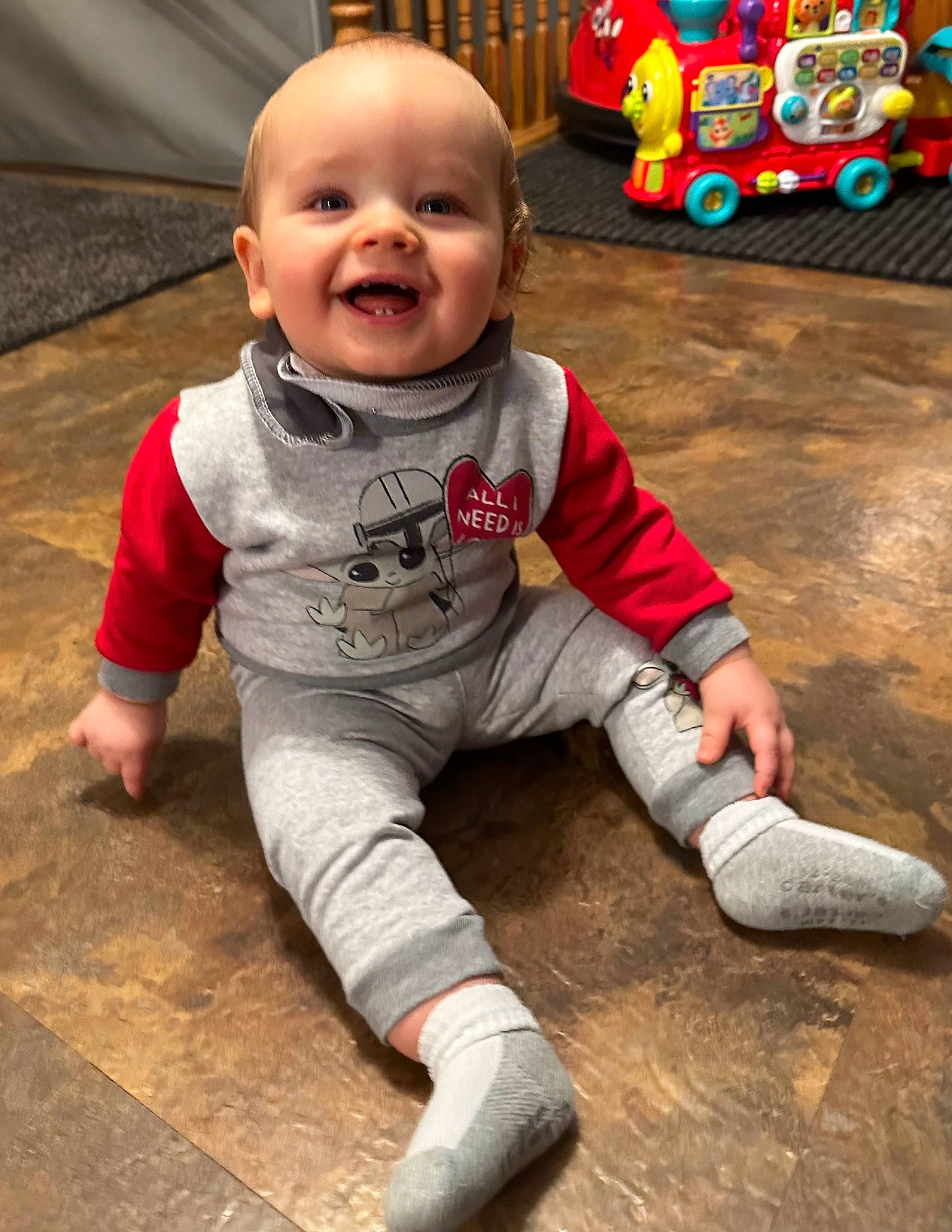 Leo is registered to the contest to win money with this photo: baby, baby_toddler_clothing, cheek, child, chin, eye, floor, flooring, fun, happy, joy, leg, nose, person, play, sitting, skin, sleeve, smile, toddler