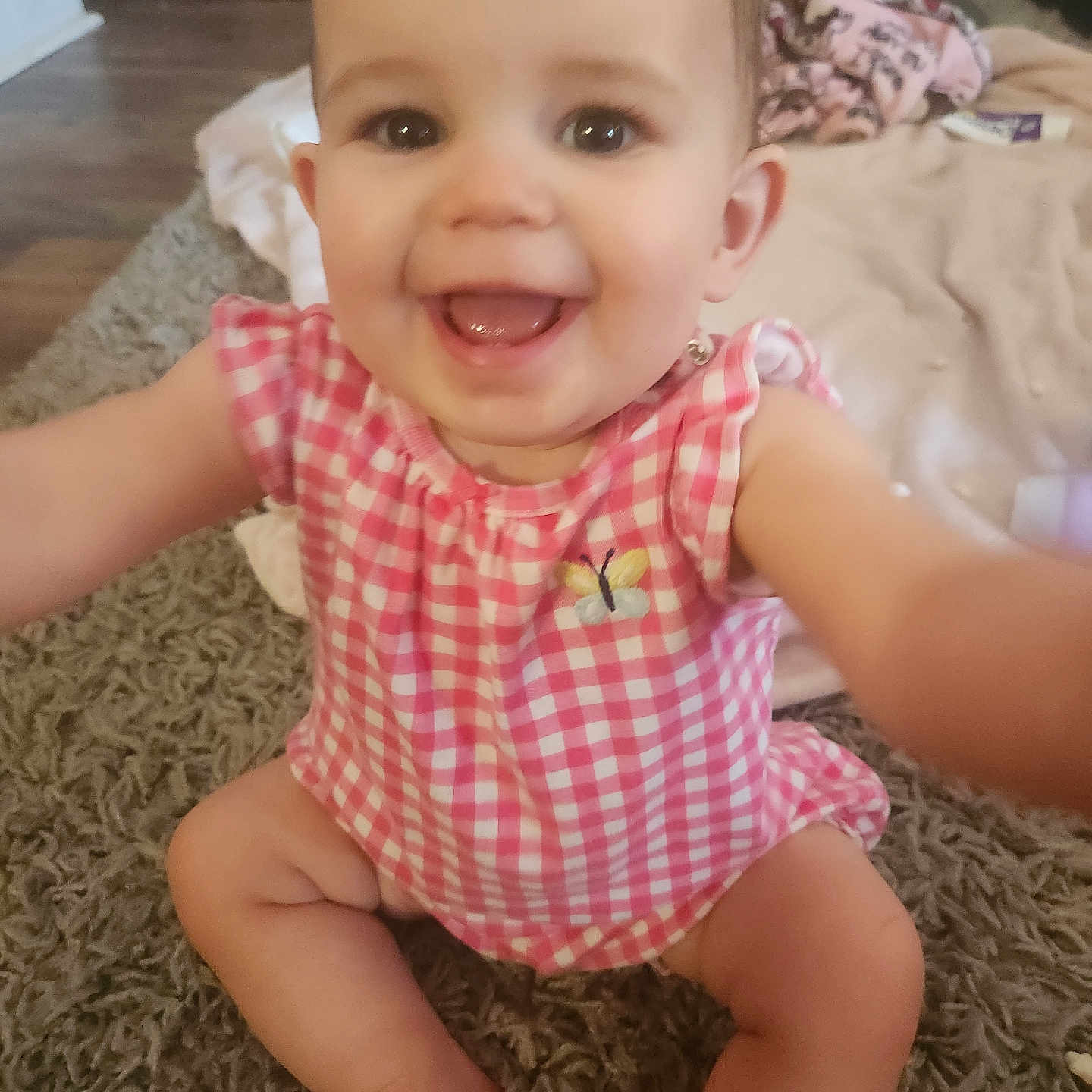 Novalea joined the competition — help win amazing prizes! baby, child, smiling, pink_clothing, sitting, carpet, indoor, person, cute, happy, infant, home, blanket, floor, cheerful, portrait, young_child, reaching, closeup, playful
