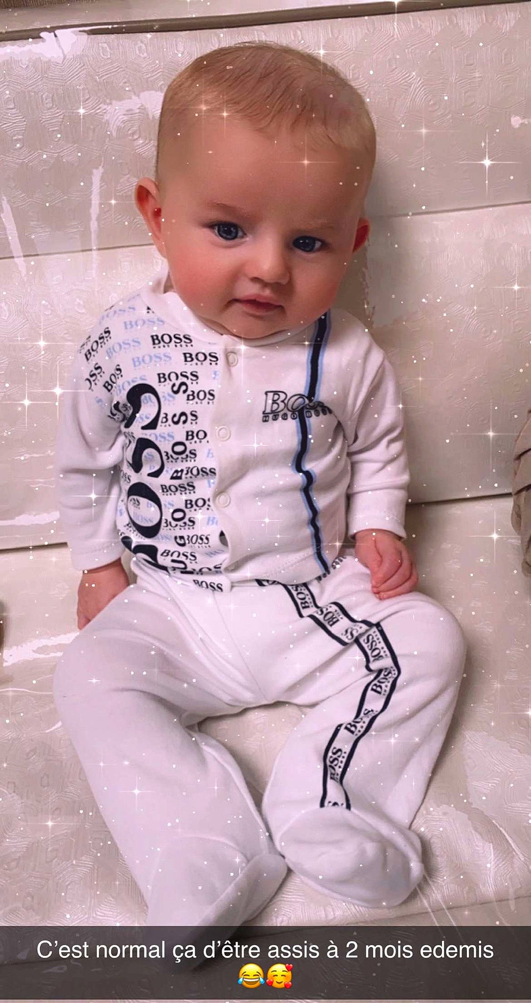 Elyas participe au concours pour gagner de l'argent avec cette photo : arm, baby, baby_products, baby_toddler_clothing, cheek, chest, child, chin, face, happy, head, human_body, iris, outerwear, pattern, person, pink, sitting, skin, sleeve