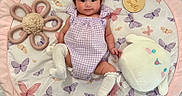 Rhylee is registered to the contest to win money with this photo: baby, infant, child, play_mat, butterfly_pattern, purple_outfit, white_socks, plush_toy, flower_toy, cute, smiling, lying_down, soft_texture, indoor, floor, decorative_mat, happy, young_child, adorable, portrait