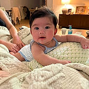 Rhylee is registered to the contest to win money with this photo: baby, infant, face, arm, pillow, blanket, hand, living_room, lamp, furniture, person, home_interior, couch, soft_texture, cute, child, portrait, comfort, relaxation, indoor