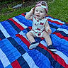 Liam is registered to the contest to win money with this photo: baby, child, outdoor, grass, blanket, cap, hat, shoes, smile, happy, blue_eyes, sitting, cute, infant, playful, summer, casual_clothing, portrait, colorful, daylight