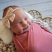Everly joined the competition — help win amazing prizes! baby, bow, child, closeup, cozy, cute, headband, indoors, infant, knitted_cushion, newborn, peaceful, pink_blanket, portrait, resting, sleeping, smiling, soft_texture, woven_backdrop, wrapped