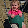 Nakoa is registered to the contest to win money with this photo: backyard, child, curly_hair, daylight, grass, green_swing, happy, house, metal_chains, outdoor, person, pink_shirt, playground, shadow, shorts, smiling, summer_clothing, sunny, swing, toddler