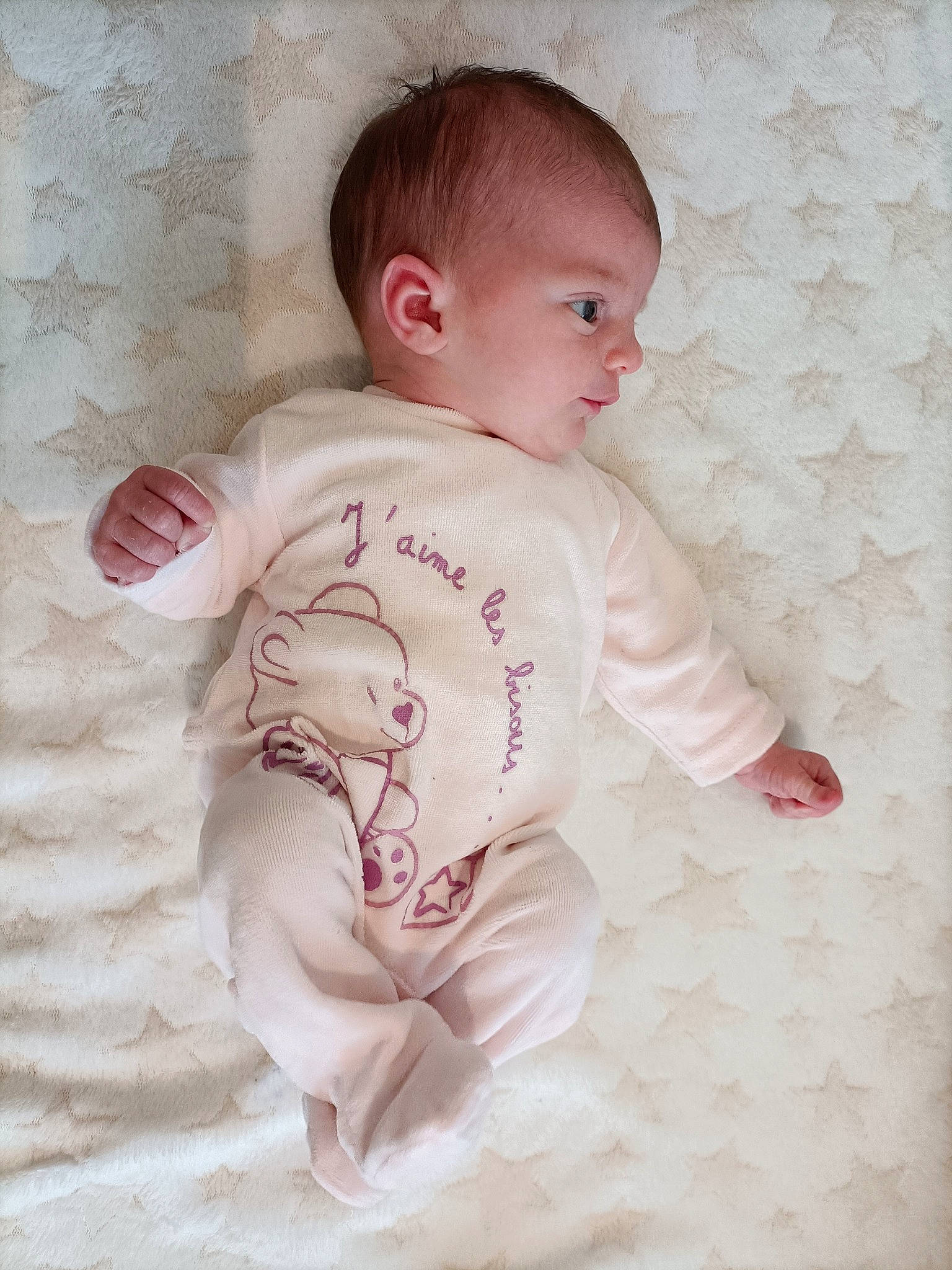 Maëline participe au concours pour gagner de l'argent avec cette photo : baby, baby_toddler_clothing, bedding, cheek, child, comfort, dress, eye, fur, happy, human_body, iris, linens, lip, pattern, person, pink, sitting, sleeve, t_shirt