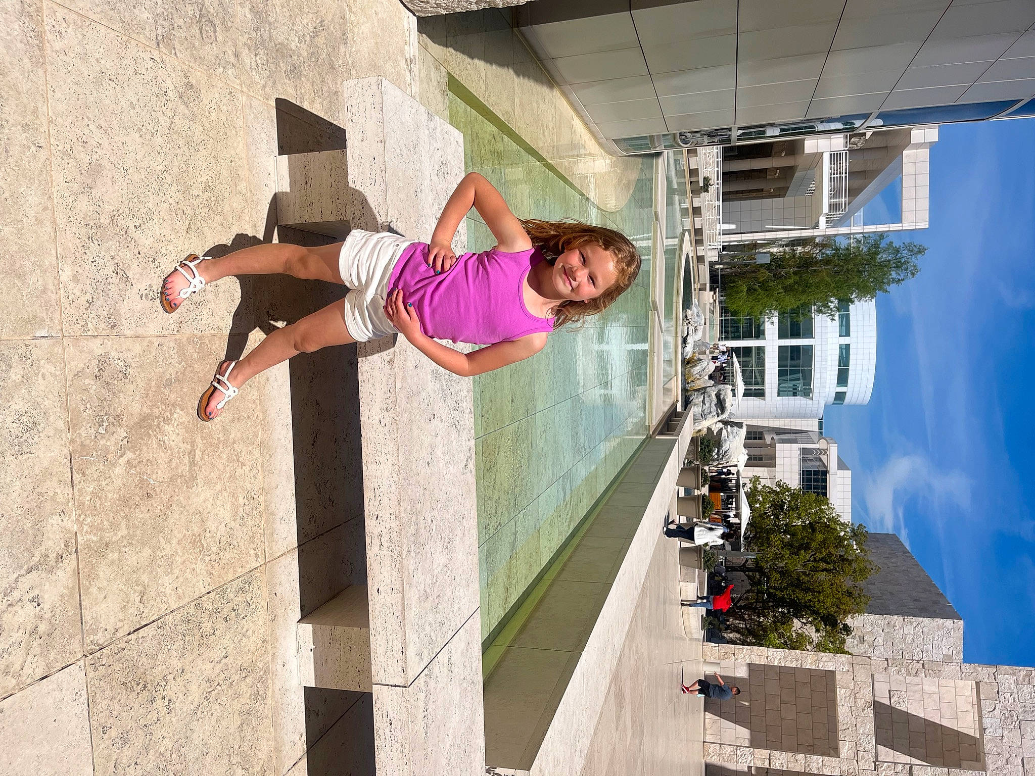 Addi is registered to the contest to win money with this photo: adventure, building, concrete, facade, fun, happy, human_leg, joy, leisure, magenta, person, plant, recreation, shorts, sky, smile, stairs, thigh, town, travel