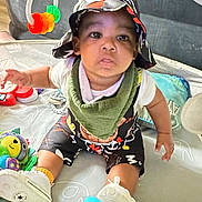 Taevon joined the competition — help win amazing prizes! baby, child, hat, bib, toy, playpen, sitting, curious, colorful, indoor, footwear, clothing, infant, expression, face, hand, floor, play, young, person