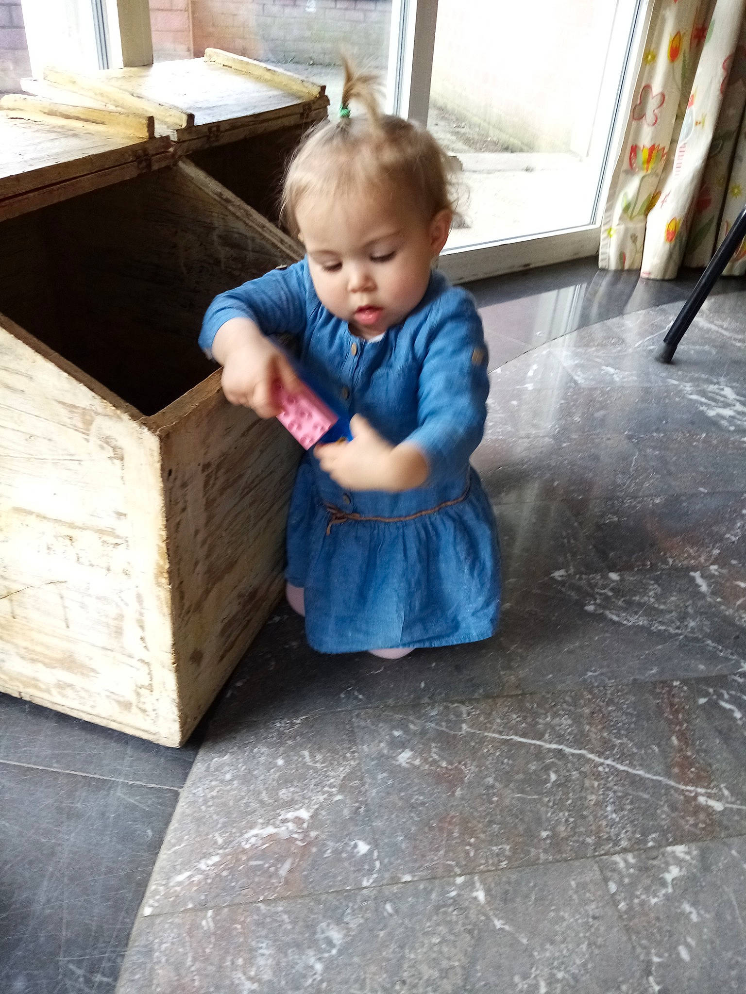 Brittany participe au concours pour gagner de l'argent avec cette photo : baby, child, floor, flooring, furniture, house, leg, person, play, shoe, sitting, table, toddler, wood