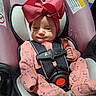 Olivia is registered to the contest to win money with this photo: baby, infant, child, car_seat, safety_harness, pink_outfit, red_bow, portrait, face, smiling, sitting, indoors, vehicle, travel, harness, infant_clothing, patterned_clothing, headband, photography, cute