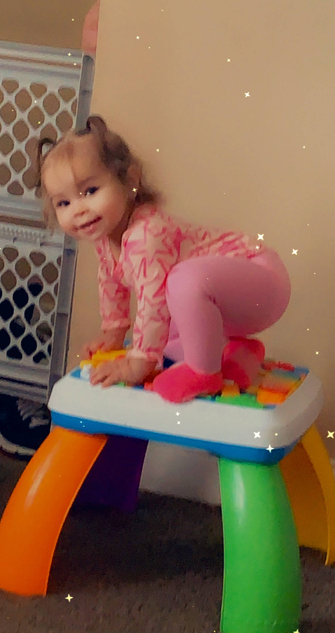 Melodi is registered to the contest to win money with this photo: arm, baby, baby_playing_with_toys, baby_toddler_clothing, baby_toys, child, clothing, fun, human_leg, joy, leg, leisure, magenta, person, pink, room, sitting, skin, sleeve, standing