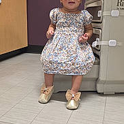 Joseinmy is registered to the contest to win money with this photo: toddler, child, sunglasses, dress, floral_pattern, headband, shoes, bow, medical_room, floor_tiles, cabinet, medical_equipment, purple_wall, bracelet, standing, cute, indoor, person, baby, fashion