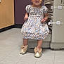 toddler, child, sunglasses, dress, floral_pattern, headband, shoes, bow, medical_room, floor_tiles, cabinet, medical_equipment, purple_wall, bracelet, standing, cute, indoor, person, baby, fashion