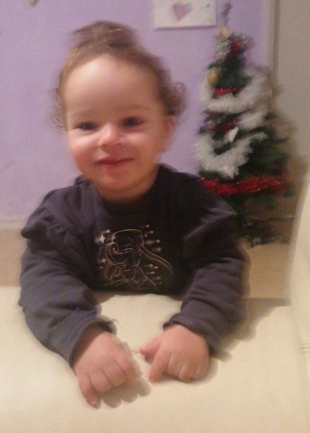 Zohra a rejoint le concours — aidez-le/la à gagner de superbes lots ! baby_toddler_clothing, cheek, child, christmas, christmas_decoration, christmas_ornament, christmas_tree, event, face, flooring, fun, happy, head, human_body, joy, person, sitting, sleeve, smile, standing