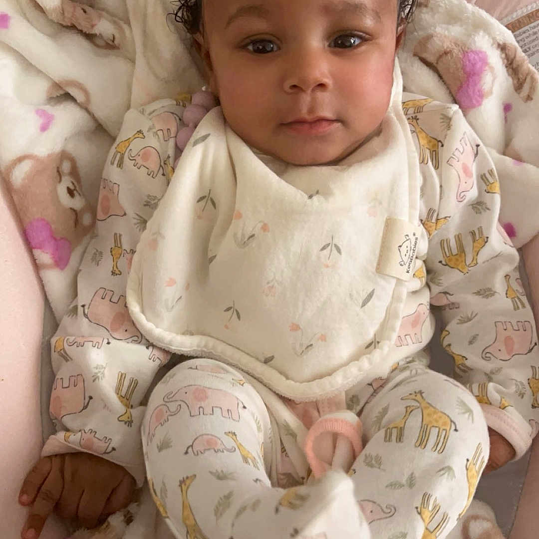 Savani joined the competition — help win amazing prizes! baby, blanket, clothing, crib, cushion, diaper, face, furniture, happy, head, homedecor, infantbed, newborn, pajamas, person, photography, portrait, sitting, sleeve, smile