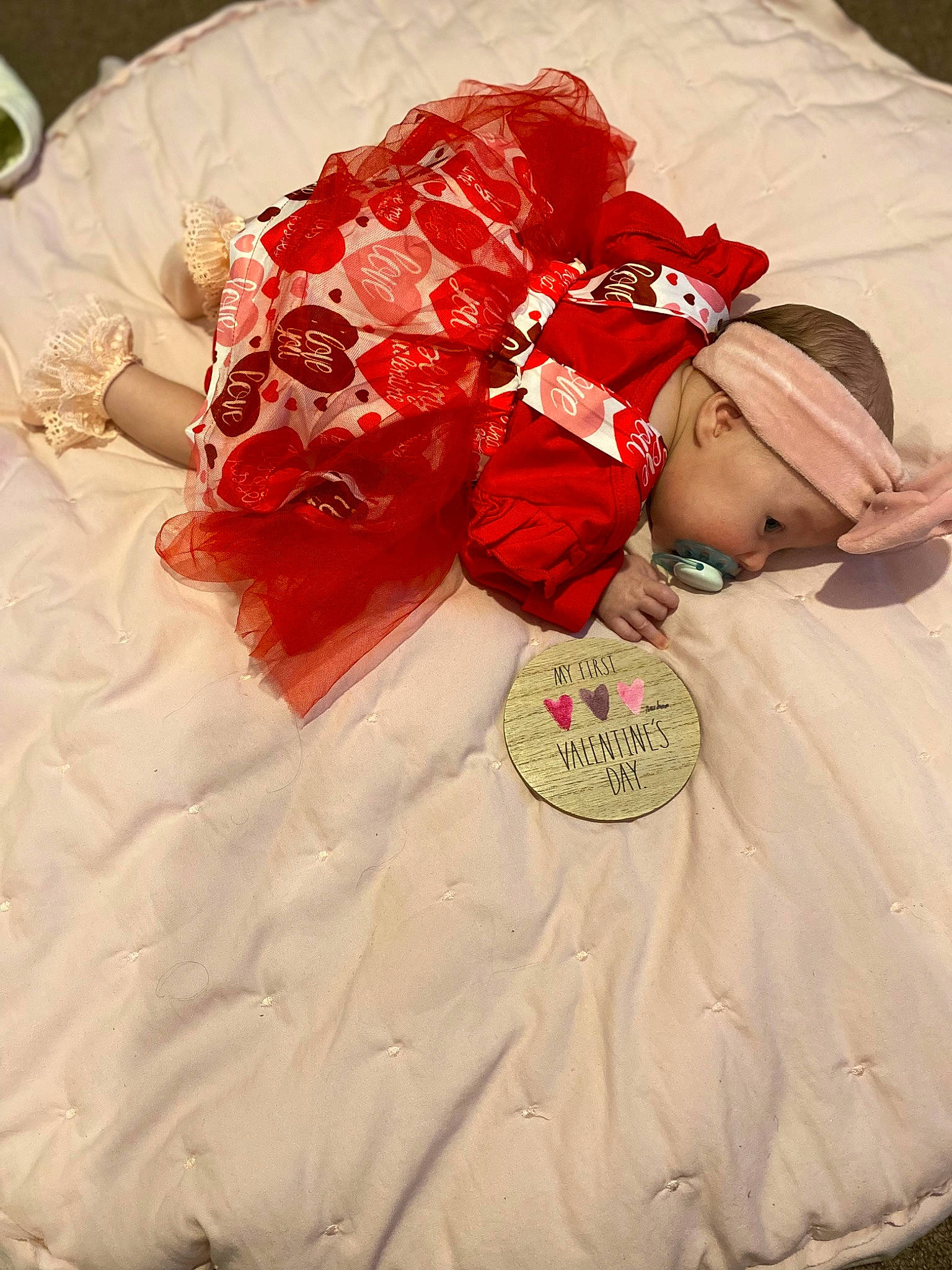 Arilynn is registered to the contest to win money with this photo: baby, baby_toddler_clothing, carmine, costume_hat, dress, event, fashion_accessory, flower, hat, headband, headgear, headpiece, jewellery, linens, peach, person, petal, pink, sleeve, textile