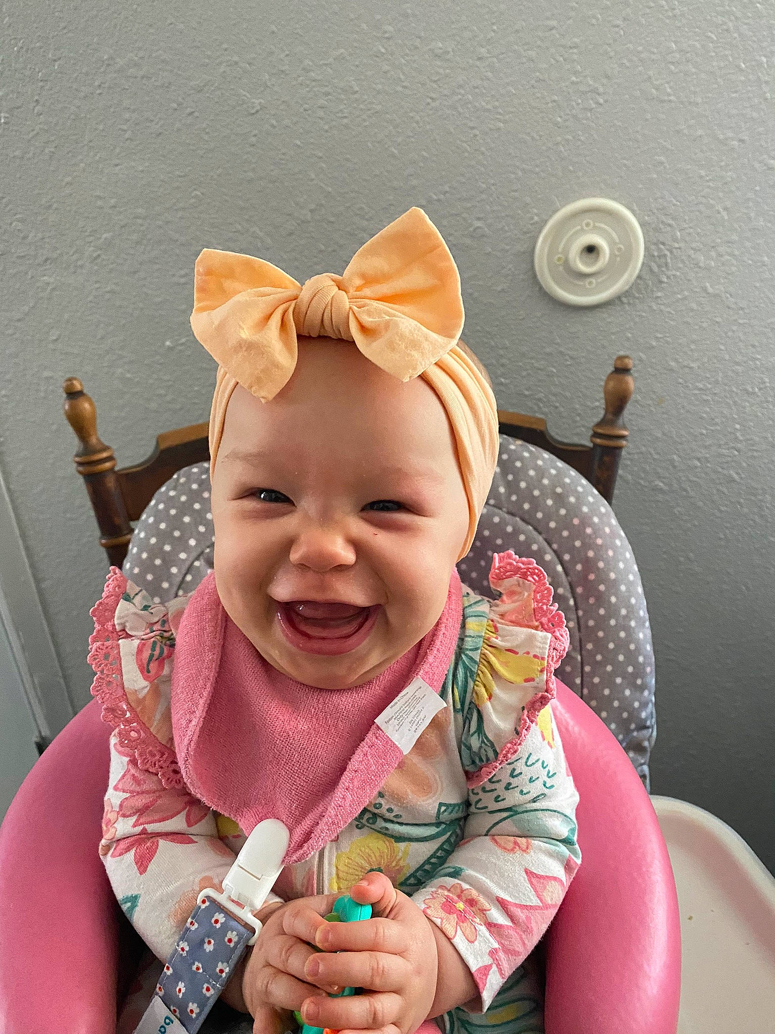 Arilynn is registered to the contest to win money with this photo: arm, baby, baby_products, baby_toddler_clothing, baby_toys, child, comfort, fashion_accessory, finger, fun, gesture, happy, magenta, person, pink, sitting, skin, sleeve, smile, thumb