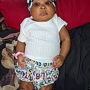 Egypt joined the competition — help win amazing prizes! baby, child, infant, portrait, lying_down, bed, indoor, bow_headband, checkerboard, white_shirt, patterned_shorts, socks, dark_skin, face, eyes, serious_expression, fashion, textile, bedding, photography