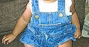 Egypt is registered to the contest to win money with this photo: baby, child, infant, sitting, portrait, smiling, bow, denim, overalls, dress, couch, furniture, indoor, home, face, eyes, feet, toes, clothing, photography