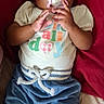 baby, infant, child, portrait, pacifier, smiling, sitting, lying_down, red_background, colorful_clothing, blue_pants, shirt, hands, face, eyes, indoors, cozy, candid, baby_fashion, happy