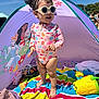 barefoot, beach_tent, cartoon, child, colorful, daylight, happy, outdoor, playing, princess, purple, sand, striped_towel, summer, sunglasses, sunny, swimsuit, toddler, toy, yellow