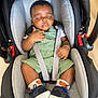 baby, sleeping, car_seat, green_overalls, socks, shoes, infant, child, seatbelt, black_hair, closed_eyes, bracelet, indoor, floor, comfort, cute, resting, toddler, infant_clothing, peaceful