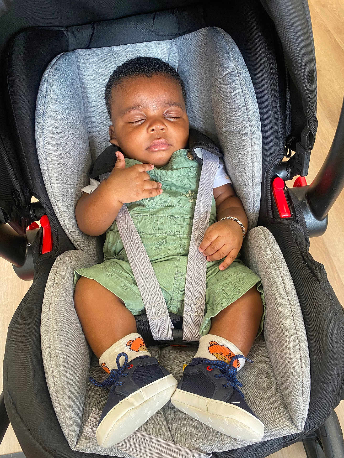 Soualiho a rejoint le concours — aidez-le/la à gagner de superbes lots ! baby, sleeping, car_seat, green_overalls, socks, shoes, infant, child, seatbelt, black_hair, closed_eyes, bracelet, indoor, floor, comfort, cute, resting, toddler, infant_clothing, peaceful