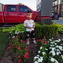 Wasat joined the competition — help win amazing prizes! child, toddler, flowers, garden, red_truck, greenery, sidewalk, building, outdoor, plants, shoes, vest, bow_tie, curious, daylight, urban, nature, cute, standing, casual_clothing