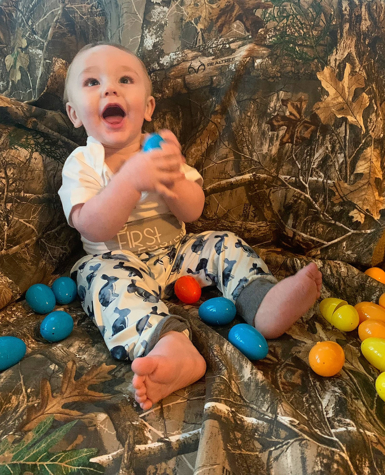 Huxley is registered to the contest to win money with this photo: adaptation, baby, baby_toddler_clothing, child, fun, grass, happy, leaf, leisure, nature, people_in_nature, person, sitting, smile, soil, spring, summer, sunlight, surprise, thigh